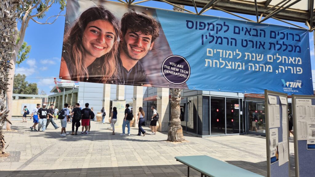 פתיחת שנת הלימודים תשפ"ו - תמונה של הכניסה למכללה עם הסטודנטים החדשים עם שלט ברוכים הבאים
