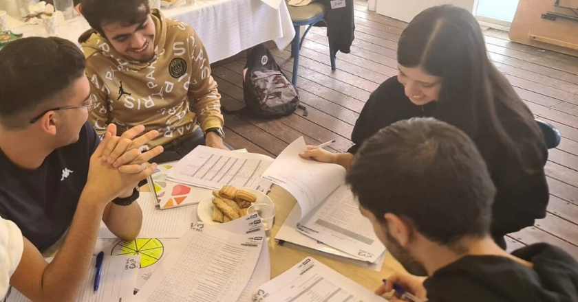 סטודנטים יושבים מסביב לשולחן ועושים עבודה ביחד